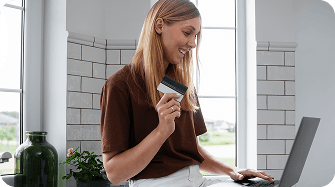 Woman with payment card at laptop
