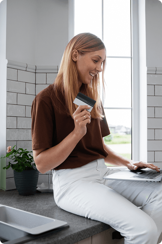 Woman with payment card at laptop